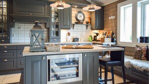 A kitchen with dark cabinets, a central island, pendant lights, and a window with a view. - Lovely home in Vossestrand with WiFi (Vossestrand)
