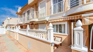 A row of Mediterranean-style buildings with balconies, a covered patio area, and a paved walkway. - Beach front home in Santa Pola (Santa Pola)