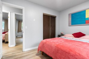 Een slaapkamer met een bed, een kledingkast en een schilderij aan de muur.