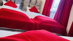 A hotel room with a bed featuring red bedding and a grey headboard. - story Hostel Hamburg (Hamburg)