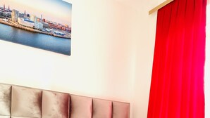 A hotel room with a large bed, red bedding, and a cityscape view. - story Hostel Hamburg (Hamburg)