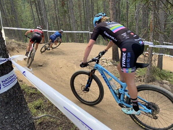 A mountain biking race with participants on a dirt trail.