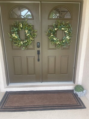 Double doors with arched windows and a welcoming wreath adorn the entrance, offering a secure and inviting start to your stay.