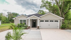 Ein eingeschossiges Haus mit Garage, Eingangstür und Auffahrt.