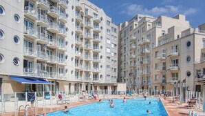 A swimming pool surrounded by multi-story residential buildings with balconies. - Gorgeous apartment in Oostende (Oostende)