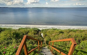 Escales que condueixen a una platja amb vista a l'oceà.