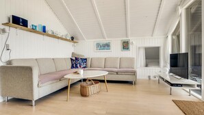 Un salon moderne avec un canapé, une table basse et un téléviseur.