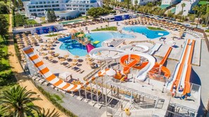 Ein Resort mit mehreren Schwimmbecken, Wasserrutschen und Liegestühlen.