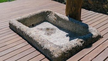 A stone planter box on a wooden deck.