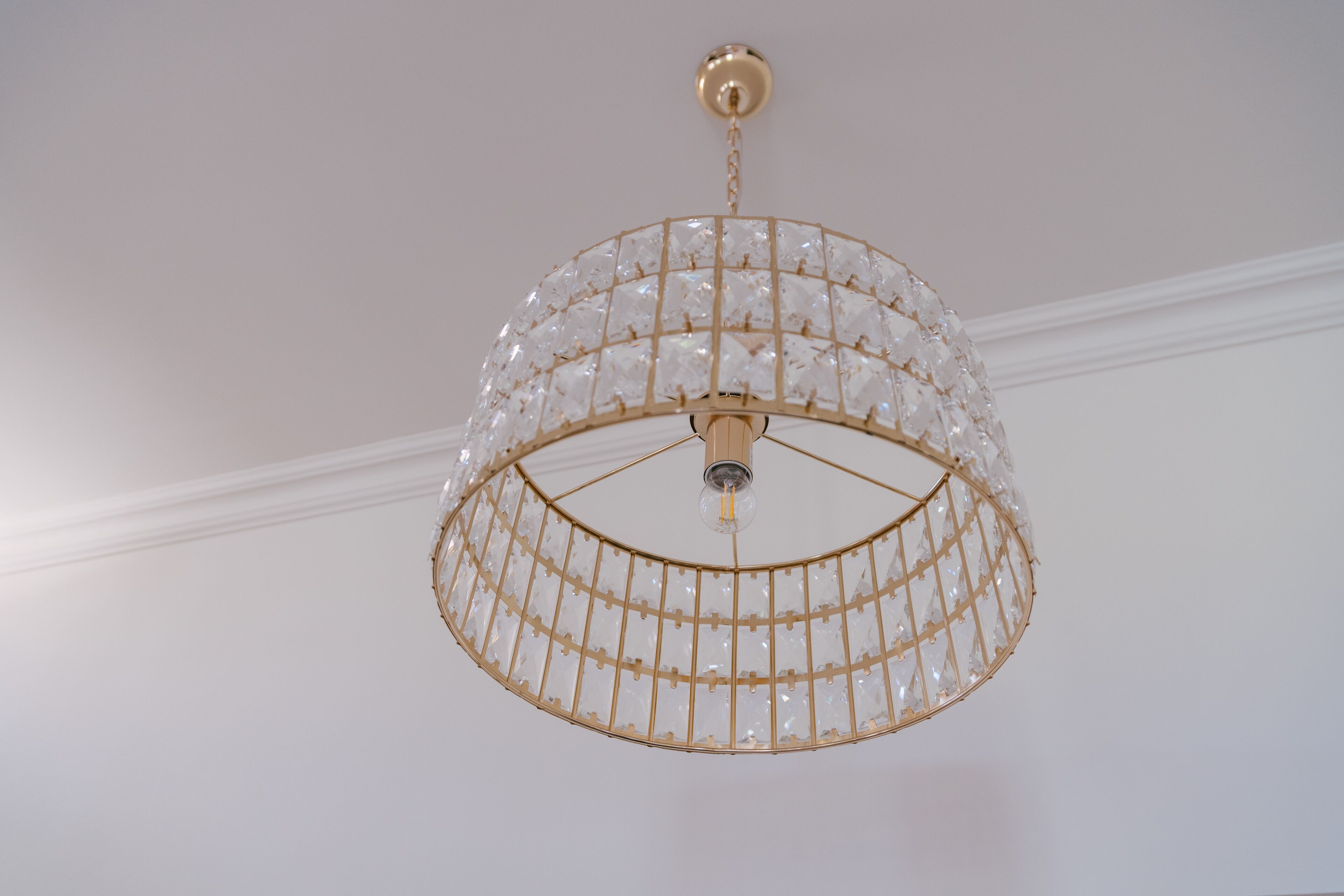 A chandelier with a gold frame and clear crystals.