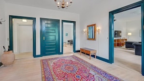 A spacious living room with a large mirror, a chandelier, and a colorful rug. - 6 bedroom gorgeous home in Kværndrup (Kværndrup)