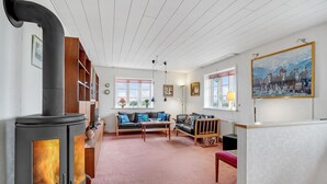 A cozy living room with a fireplace, sofas, and a painting on the wall. - Gorgeous home in Lemvig with WiFi (Lemvig)