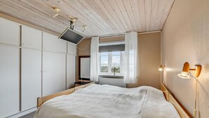 A bedroom with a bed, a TV mounted on the ceiling, a window with curtains, and a wall-mounted light fixture. - Gorgeous home in Lemvig with WiFi (Lemvig)