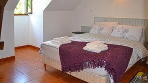 Ein Schlafzimmer mit Bett, Nachttisch, Fenster und Deckenleuchte.
