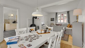 A modern living room with a dining table set for two, a fireplace, and a sofa. - 3 bedroom nice home in Kværndrup (Kværndrup)