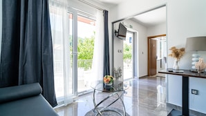 Une chambre d’hôtel moderne avec une table en verre, un canapé et une vue sur l’extérieur.