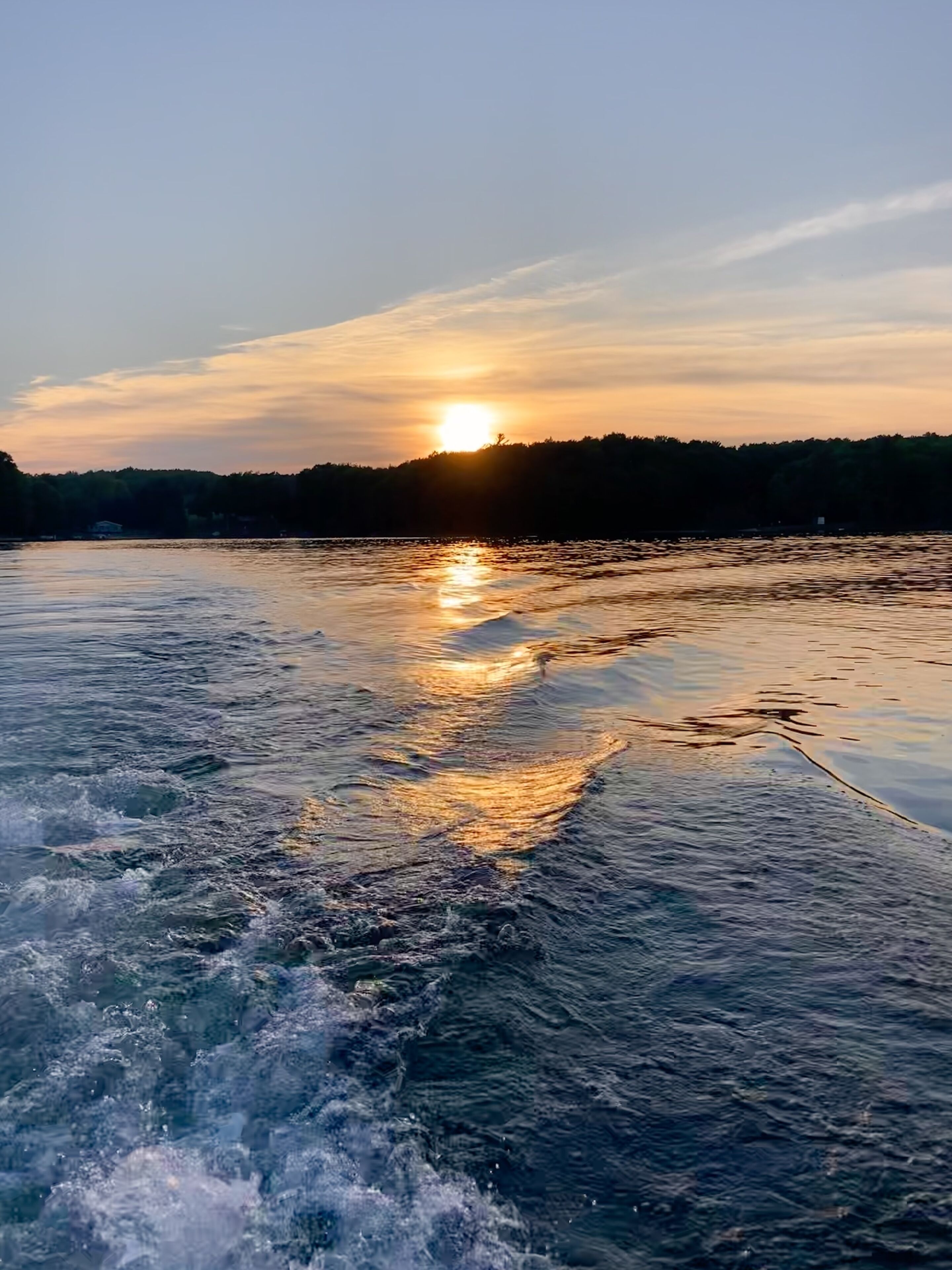A body of water with a sunset in the background.