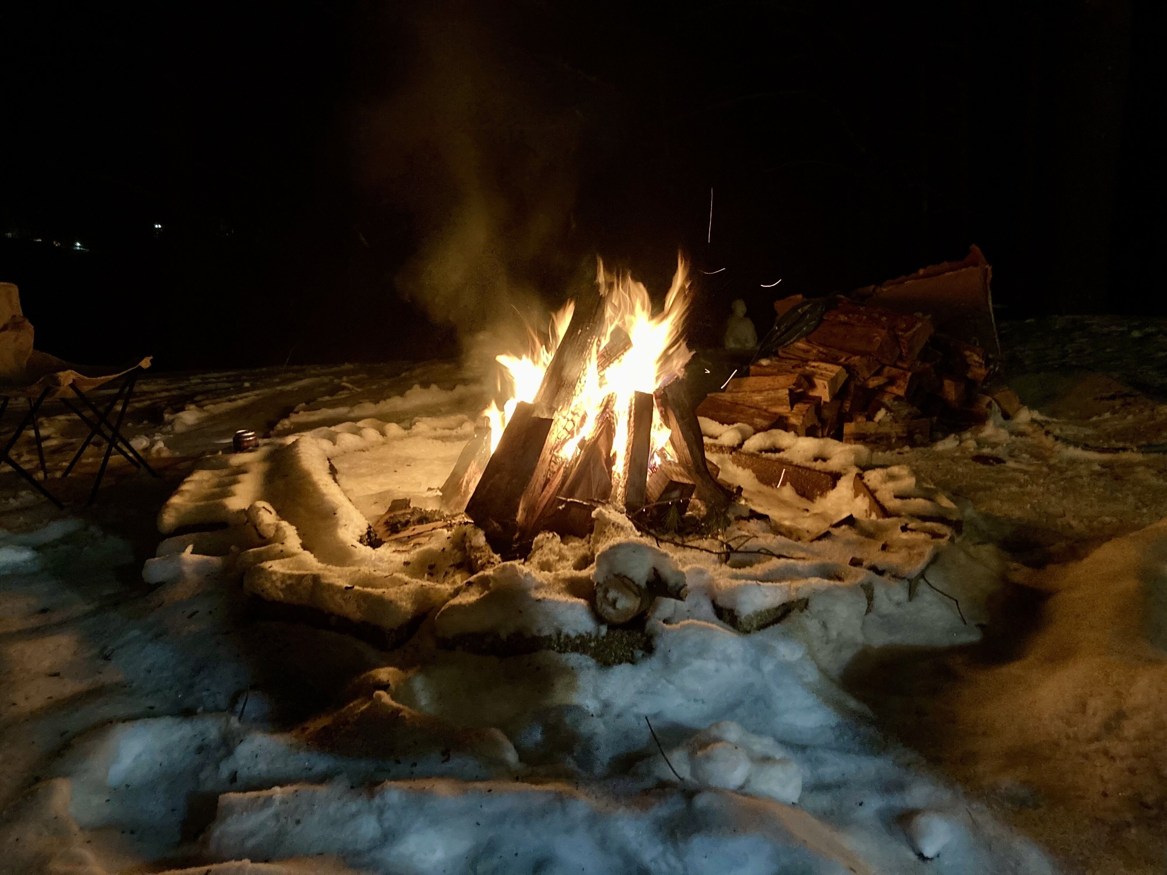 A campfire surrounded by snow.