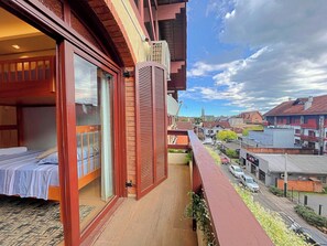 Un balcon avec un lit, une antenne parabolique et une vue sur la ville.