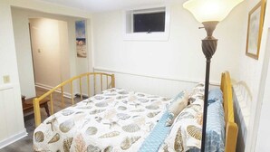 A bedroom with a bed, a nightstand, a lamp, a window, and a door leading to another room. - 4 min walk to the beach. 1BD. Pets Ok FREE parking (Old Orchard Beach)