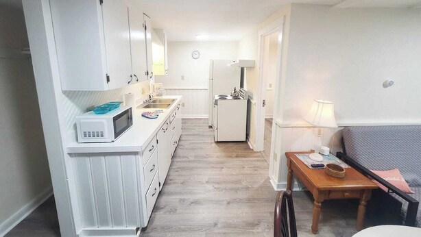A compact kitchen with white cabinets, a microwave, a sink, and a small refrigerator. - 4 min walk to the beach. 1BD. Pets Ok FREE parking (Old Orchard Beach)