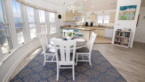 A spacious kitchen with a central island, large windows, and a chandelier. - Semi-Oceanfront, Private Pool, Hot Tub, Close to beach! WL1066, Schemering Seas (Corolla)