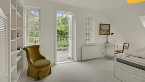 A bedroom with a bed, a desk, a chair, and a radiator. There are two windows and a door leading to an outdoor balcony. - Stunning home in Kværndrup with WiFi (Kværndrup)