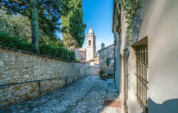 A narrow cobblestone street flanked by stone buildings, a church with a bell tower, and a clear blue sky. - Gorgeous apartment in Verucchio with WiFi (Verucchio)