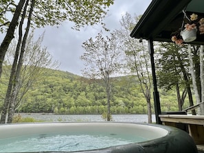 A hot tub surrounded by trees and a lake. - Cozy lakefront cottage w/seasonal hot tub. Mountain views, minutes to town/ocean (Camden)