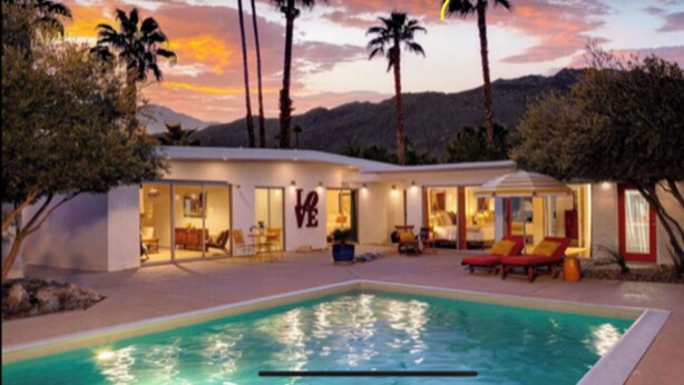 A modern hotel with a swimming pool, outdoor seating, and a view of mountains at sunset. - Original Donald Wexler Midcentury Gem with Pool in famous East Moviestar Colony (Palm Springs)