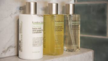 Tres botellas de productos herbales LINDEN LEE sobre una superficie de mármol.