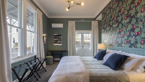 A hotel room with a large bed, a desk, and a view of the street. - The Vicarage Geraldine (Geraldine)