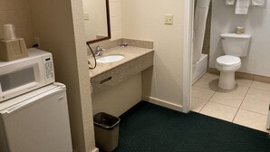 A bathroom with a sink, mirror, toilet, and shower.