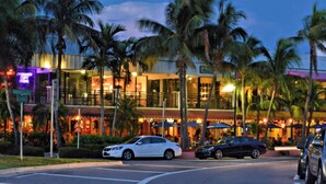 A hotel with a two-story structure, palm trees, and a street with parked cars. - Newly remodeled beach house by Lido Beach and private pool (Sarasota)