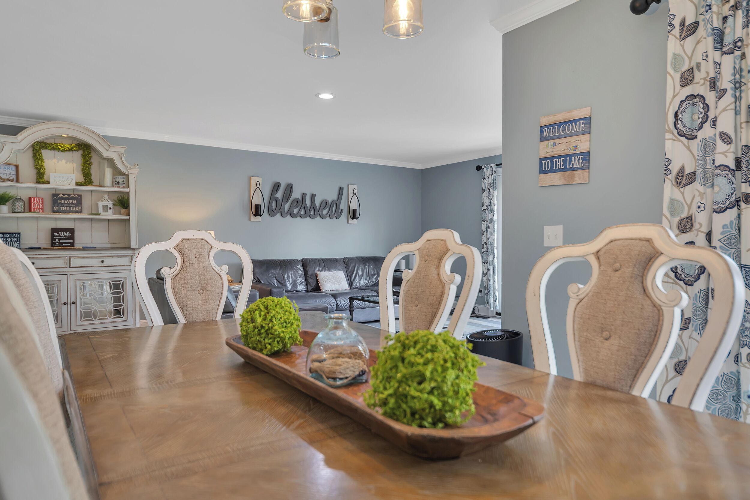 A dining room with a wooden table, two chairs, and decorative items.