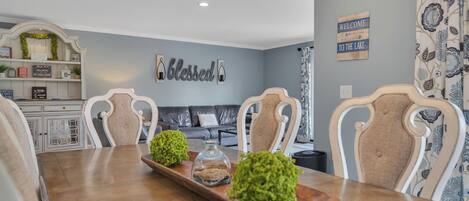 A dining room with a wooden table, two chairs, and decorative items.