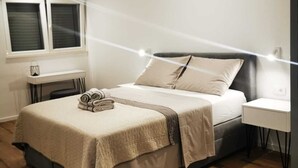 A modern bedroom with a bed, bedside tables, and a window. - Villa Marijo with sea view and pool, Croatia (Razanj)