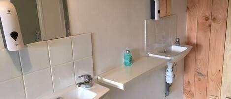 Un baño con dos lavamanos, un espejo y una puerta de madera.