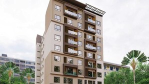 A multi-story residential building with balconies, a covered entrance, and surrounding greenery. - Cebu Family Suites powered by Cocotel (Cebu City)
