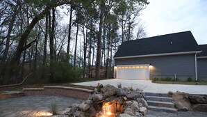 Una casa moderna con un hogar de piedra y un garaje.