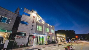 A multi-story building with a ground-level entrance, large windows, and a visible sign with Korean characters.