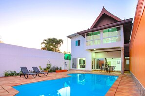 A two-story house with a swimming pool, lounge chairs, and a dining area. - Holiday Bliss 3BR Pool Villa Lancelot 2 (Rawai)