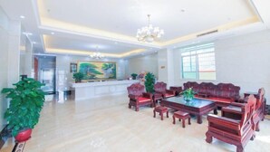 A spacious lobby with a high ceiling, wooden furniture, and a large painting on the wall. - Hao Ye Hotel (Yangjiang)