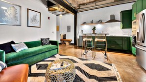 Una sala de estar moderna con un sofá verde, una mesa de centro y una alfombra estampada.