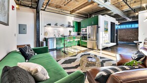Una cocina moderna con gabinetes verdes, electrodomésticos de acero inoxidable y una isla visible.