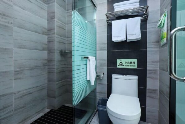 A modern bathroom with a glass shower enclosure, a white toilet, and a towel rack with white towels. - Qingmu Hotel (Jiangyan Renmin Middle Road Branch) (Taizhou)