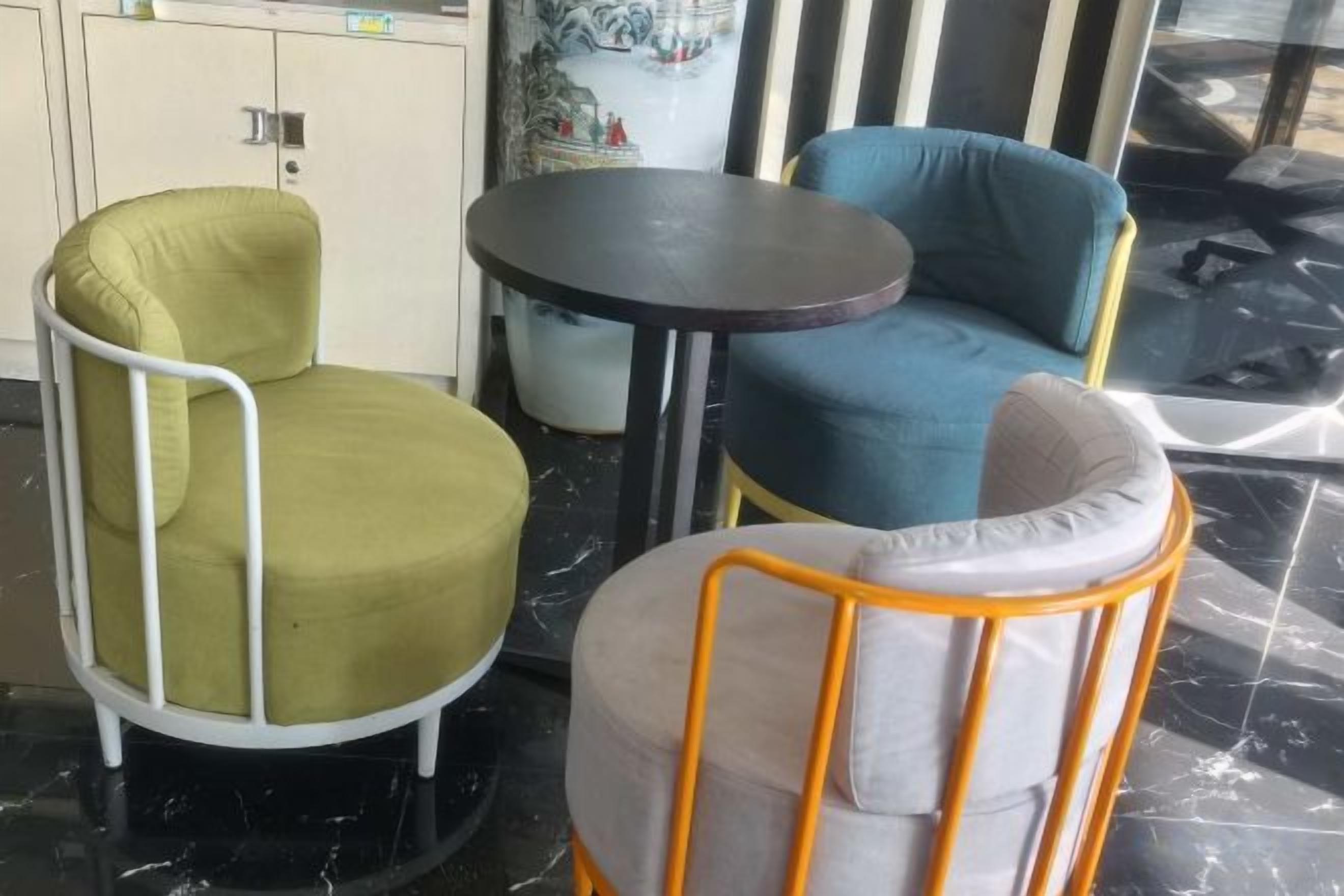 A seating area with three chairs and a small round table, likely in a hotel or similar accommodation.