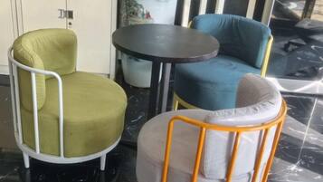 A seating area with three chairs and a small round table, likely in a hotel or similar accommodation.