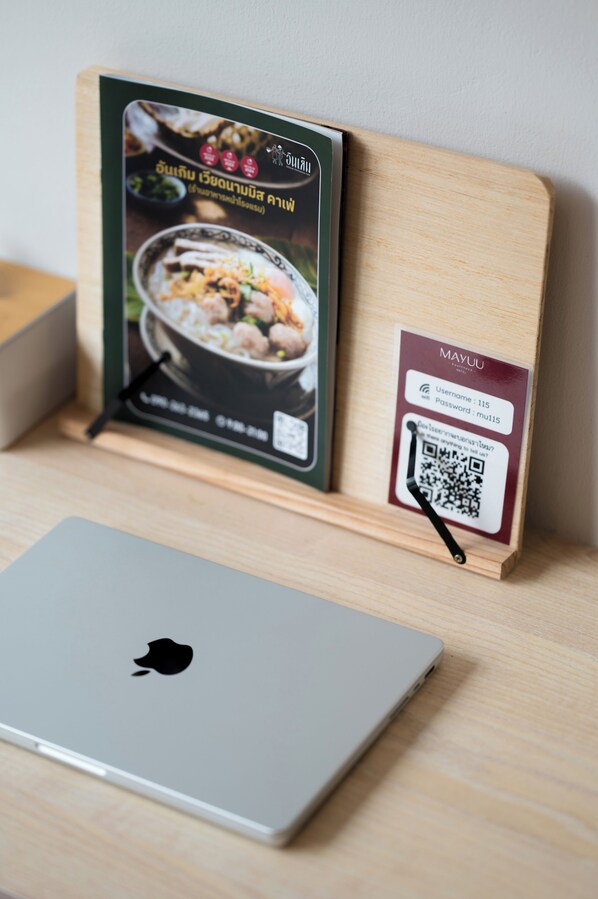 Un tablero de madera con un código QR y una computadora portátil sobre una superficie de madera.
