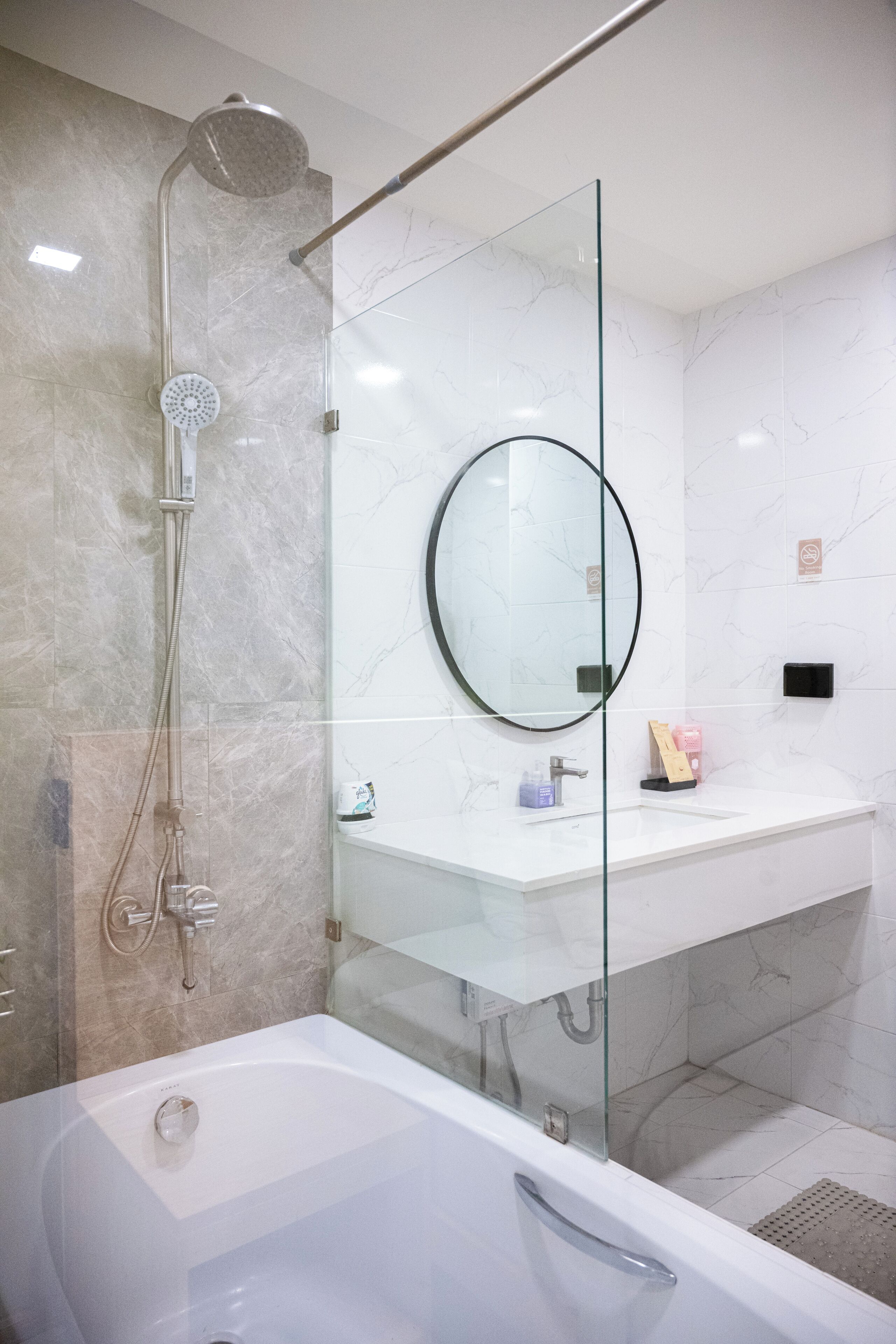 A modern bathroom with a glass-enclosed shower, a standalone bathtub, and a vanity with a mirror.